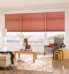 a living room filled with furniture and windows covered in red roller shade shades on top of them