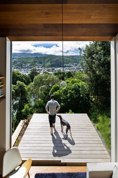 a man standing on top of a wooden deck next to a dog