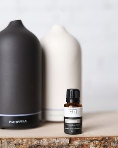 a bottle of essential oil next to a black and white jug