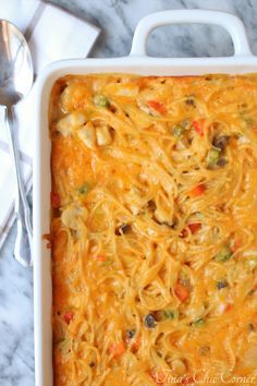 a casserole dish with noodles and vegetables in it on a marble counter top