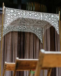 an ornate white canopy over a wooden chair