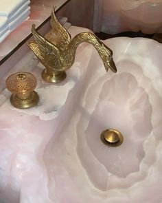 a bathroom sink with a gold bird faucet