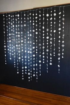 a blackboard with white flowers hanging from it's sides in front of a wooden floor