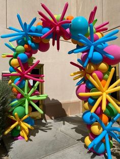 an arch made out of balloons in front of a building