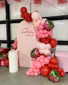 a bunch of balloons that are in the shape of a heart and some strawberries