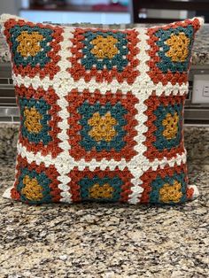 a crocheted pillow sitting on top of a counter