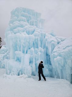 a person standing in front of an ice formation