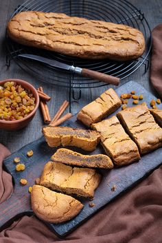 several pieces of bread sitting on top of a cutting board next to a bowl of corn