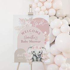 a welcome sign for a baby shower with balloons around it and an elephant in the background