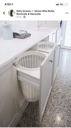 a laundry basket is in the middle of an open cabinet