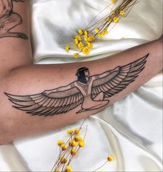 an egyptian style tattoo on the arm and leg, with yellow flowers in the foreground