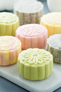 five different colored soaps sitting on top of a white tray