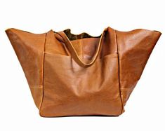 Oversized leather bag, very large soft handbag, tan leather.Height: 39 cm / 15.3"Height from top of handle to base: 68 cm / 26.8"Handle drop: 26 cm / 10.2"Width: 34 - 74 cm / 13.4" - 29.1"Depth: 28 cm / 11"- Large, very roomy bag made of soft distressed leather. - Unlined- Inside two spacious section.- Top closure magnet for security.Add this gorgeous bag to your collection!!To return to my shop, simply click here:  https://www.etsy.com/shop/BarbaraLeatherDesign********************************** Cognac Tote Travel Bag For Everyday Use, Everyday Cognac Tote Travel Bag, Cognac Large Capacity Weekender Bag, Brown Satchel With Rolled Handles For Errands, Cognac Tote Weekender Bag, Chic Brown Travel Bag For Shopping, Chic Brown Soft Leather Weekender Bag, Brown Weekender Bag With Leather Handles For Shopping, Brown Large Capacity Tote Weekender Bag