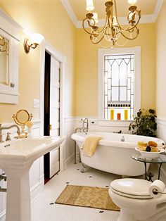 a bathroom with yellow walls and white fixtures