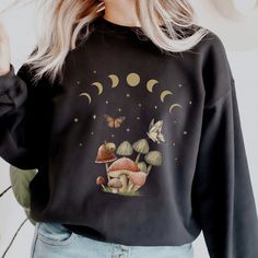 This cottagecore mystical mushroom sweatshirt is super soft and cozy. Great sweater to lounge around, run errands, or walk your dog. ABOUT THIS SHIRT ∙ The BROWN design is printed on the white and sport grey shirt ∙ The CREAM design is printed on the black, dark heather, navy, and forest green shirt ∙ Shirt is UNISEX and runs slightly large for ladies (size up for a loose boyfriend style, size down for a more fitted style) ∙ 50% cotton, 50% polyester blend fabric ∙ Colors may vary based on your Botanical Goth, Dark Academia Photos, Navy And Forest Green, Clothing Dark Academia, Fairycore Shirt, Mushroom Outfit, Mushroom Sweatshirt