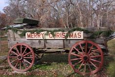 an old wooden wagon with christmas decorations on the side and merry christmas written on it