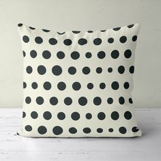 a black and white polka dot pillow sitting on top of a table