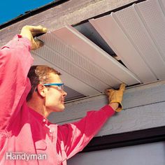 a man in pink shirt and goggles working on an overhead gutter ventilator