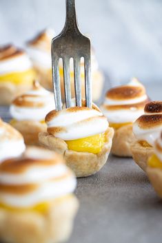 a fork is stuck into mini desserts on a tray