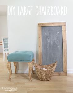 a chalkboard sitting next to a wooden bench in front of a wall with the words diy large chalkboard on it