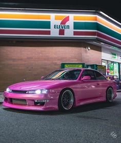 a pink car parked in front of a store