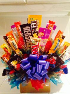 a gift box filled with assorted candy and candies, tied in a blue ribbon