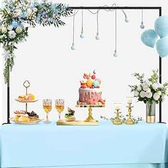 a blue table topped with a cake and lots of desserts next to balloons in the air