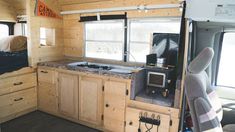 the interior of an rv with wood paneling and granite counter tops, including a sink