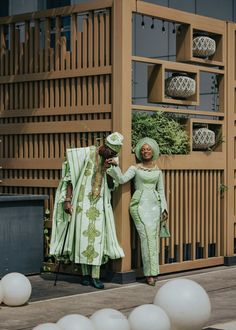 two people dressed in green standing next to each other