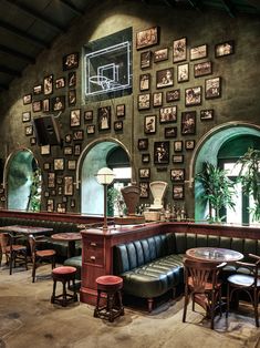 the interior of a restaurant with green walls and pictures on the wall behind the booths