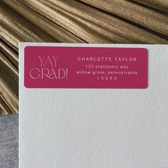 a close up of a white envelope with a pink and gold address stamp on it