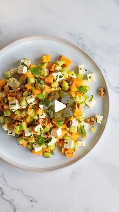 a white plate topped with chopped vegetables on top of a table