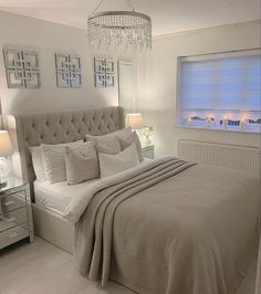 a bedroom with a large bed and chandelier