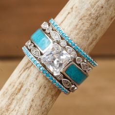 a close up of a ring on top of a wooden stick with blue and white stones