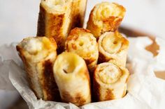 some food is sitting in a basket on the table and it looks like they are made out of bread