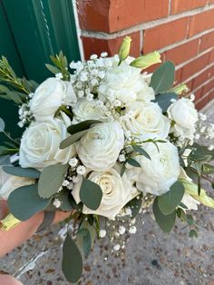 a bridal bouquet with white roses and baby's breath