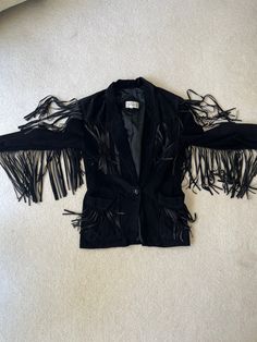 Super soft and supple leather suede jacket. Fringe on pockets, arms, shoulders and back. A true statement piece. Overall condition is great, a few missing or shortened fringe pieces. A deep rich black color with a single button closure. Please see all photos. Black Fringe Outerwear For Party, Black Fringed Leather Jacket For Fall, Black Fringe Party Outerwear, Black Leather Jacket With Fringe For Winter, Vintage Leather Jacket With Fringe For Winter, Vintage Fringe Jacket, Black Leather Fringe Jacket, Fitted Black Fringe Outerwear, Vintage Brown Fringe Outerwear