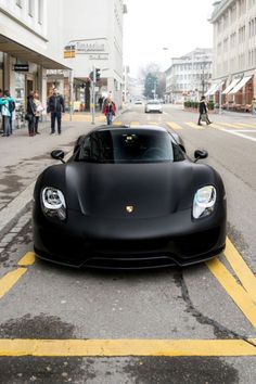 a black sports car is parked on the street