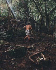 a shirtless man running through the woods