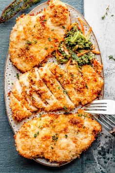 chicken with broccoli and carrots on a white plate next to a fork