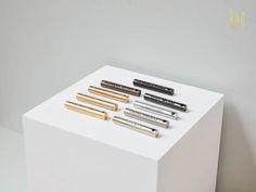 four different types of pens sitting on top of a white box next to each other