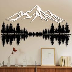 a wall decal with trees and mountains in the background, on a wall next to a dresser