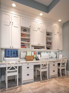 a home office with white cabinets and drawers