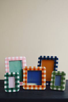 three different colored frames sitting on top of a table