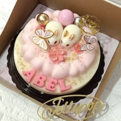 a cake in a box with pink and gold decorations