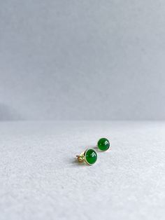 Elevate your everyday elegance with our exquisite Grade A Imperial Green Jade 18K Gold Ear Studs, a mesmerizing fusion of timeless sophistication and natural allure. Crafted with utmost care and precision, each stud features a lustrous Grade A Imperial Green Jade gemstone sourced directly from the verdant landscapes of Myanmar. Renowned for its rich green hue and exceptional clarity, this jade exudes an aura of serenity and vitality, making it the perfect companion for every occasion. Set in a luxurious 18K gold bezel, these ear studs radiate warmth and opulence, adding a touch of refinement to any ensemble. Whether you're strolling through bustling city streets or attending a lavish soirée, these studs effortlessly transition from day to night, complementing your unique style with effortl Elegant Green Polished Earrings, Elegant Green Earrings With Polished Finish, Emerald Cabochon Earrings For Gift, Emerald Cabochon Earrings As A Gift, Timeless Green Earrings As A Gift, Timeless Green Earrings For Gift, Elegant Emerald Earrings With Bezel Setting, Classic Green Earrings With Bezel Setting, Formal Green Earrings With Bezel Setting