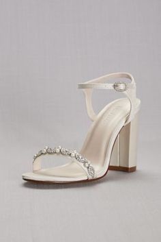 a woman's white high heeled sandal with crystal embellishment