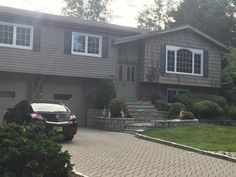 a car parked in front of a house with steps leading up to the garage door