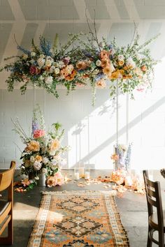 an arrangement of flowers and greenery on display in a room