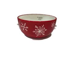 a red bowl with white snowflakes on it